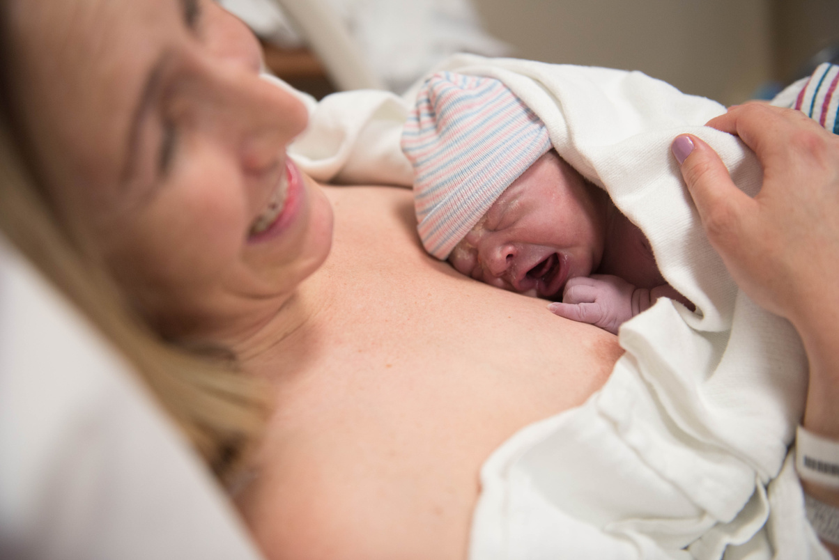 Mother laughing and smiling after giving birth